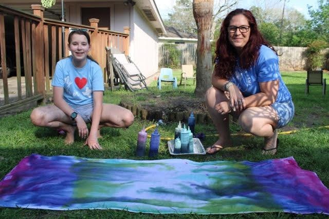 Two people posing with finished tie-dye fabric